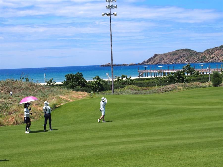 海沿いのゴルフコースでプレーする生徒たち